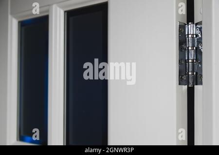 stainless door hinges on a white door Stock Photo