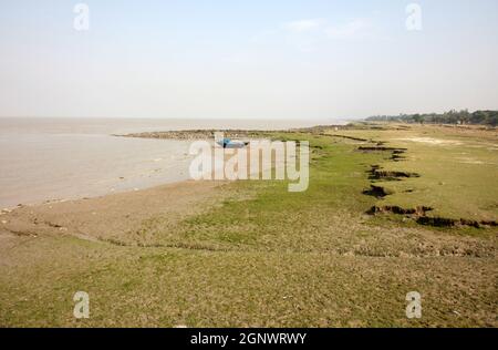 Boats of fishermen stranded in the mud at low tide on the coast of Bay of Bengal, India Stock Photo