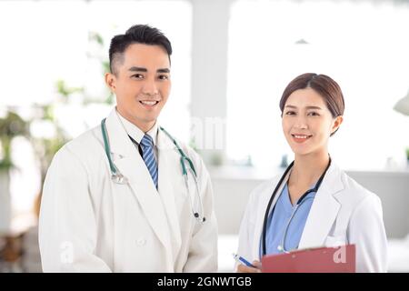 two  doctors smiling and standing  in Hospital Stock Photo