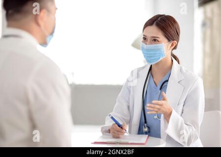 doctor explaining diagnosis to her male patient Stock Photo