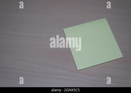 Close-up, selective focus: Yellow sticky note paper placed on a wooden table with copy space for text Stock Photo