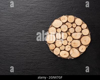 round wooden stand on black surface, top view, copy space Stock Photo