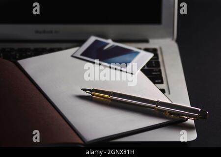 The book, the pen next to the laptop Stock Photo