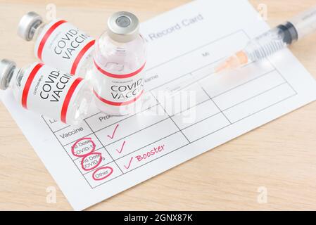 Vaccination record card showing booster dose of covid-19 vaccine. The thrid vaccination for immunity against delta variant. Stock Photo