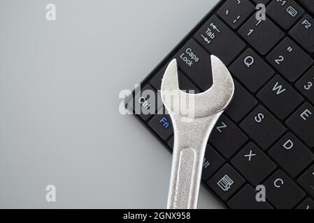 Electronic technical support concept - spanner on computer keyboard Stock Photo