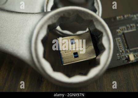 Set of spanners or wrenches in close up with jaws around a small electronic component and selective focus, technical support or smart tools concept Stock Photo