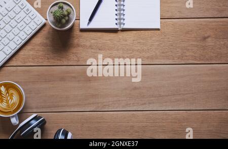 Top view of pen with other supplies, keyboard and notebook on wooden table and copy space for insert text. Stock Photo
