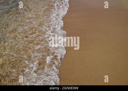 Waves lapping on the sandy shore. Sea beach. Stock Photo