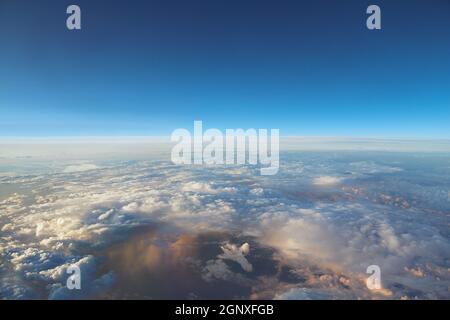 Clouds viewed from the sky with rain storm below in dramatic light Stock Photo