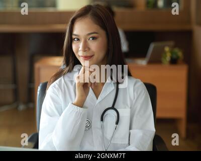 Asian young female doctor in white gown with stethoscope in office Stock Photo
