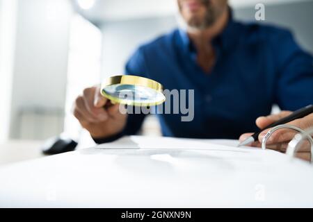 Fraud Detective Using Magnifying Glass Or Loupe Stock Photo