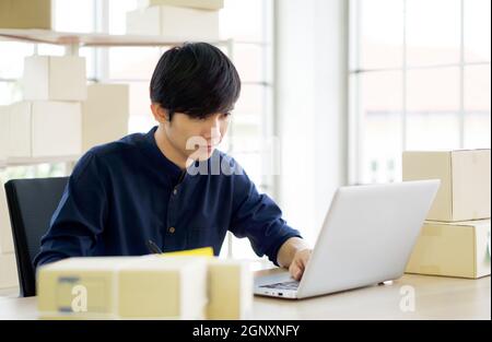 Young entrepreneur checking products stock at home office. Work from home concept. Stock Photo