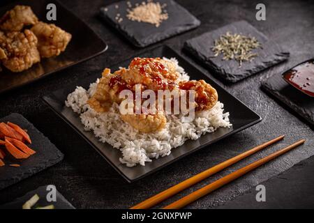 Prawns in tempura batter with sweet chilli sauce served with rice Stock Photo