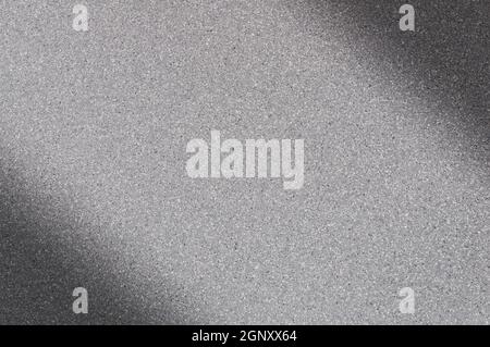 Granite background of gray color with small dots. Darkening left and right diagonally. Blurred. Stock Photo