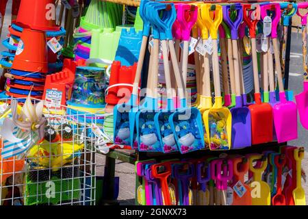 Vibrant colourful childrens plastic buckets and spades; beach toys on sale at the seaside in the UK. Stock Photo