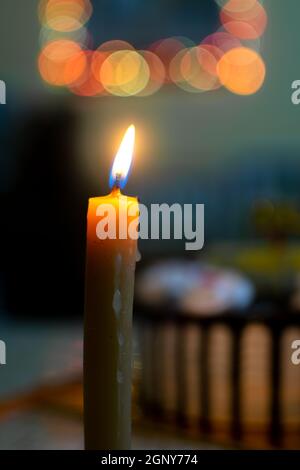Candle lightened and bokeh light with birthday cake in blurred background. Used selective focus. Stock Photo