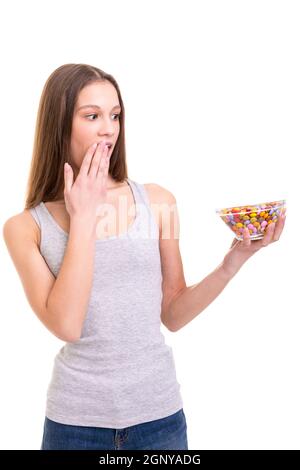 Young woman holding a bow of colorful chocolate candies, isolated over white background Stock Photo