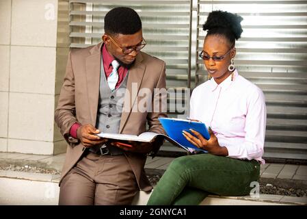 young business people talking and holding project documents in hand Stock Photo