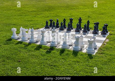 An oversized chess set stands set up on a lawn on Langeland, Denmark. Stock Photo