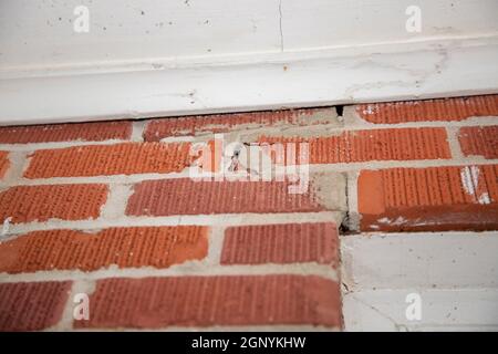 Cracked seals between the bricks above a door Stock Photo
