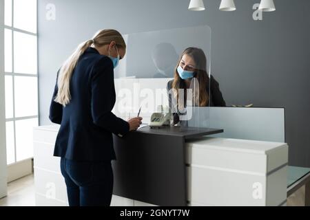 Hotel Reception Desk Protected By Medical Mask From Covid 19 Stock Photo