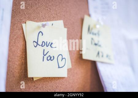 Close up of pinned note “Love you” on cork board Stock Photo