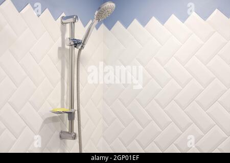 Modern shower on wall rail in modern white bathroom. Stock Photo
