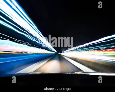 View of night city neon lights on long exposure from car's front window  Stock Photo