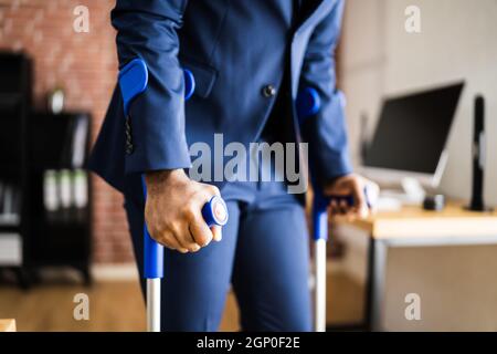 African Man Using Crutches For Recovery After Leg Fracture Stock Photo