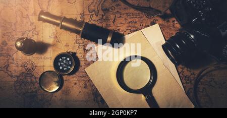 travel and adventure search concept. vintage items on old world map background Stock Photo