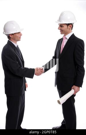 Two young Engineers closing a deal, isolated in background Stock Photo