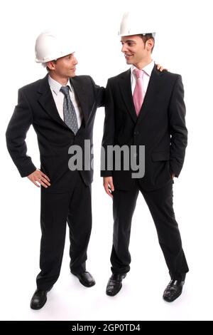 Two young Engineers closing a deal, isolated in background Stock Photo