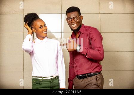 young man standing and pointing at the woman smiling Stock Photo
