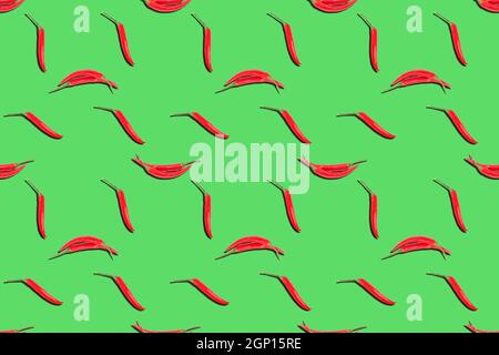 Seamless spice pattern with two forms of red chili pepper on green background. Delicious food concept Stock Photo