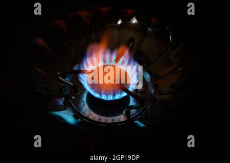 Blue flame gas stove in the dark. Selective focus with shallow depth of field. Stock Photo