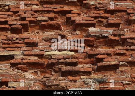 The old red brick fortress wall is crumbling. Stock Photo