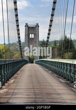 Crossing The Ancient Suspension Bridge In Saint Martin D'Ardeche France On A Beautiful Autumn Day With A Few Clouds In The Clear Blue Sky Stock Photo