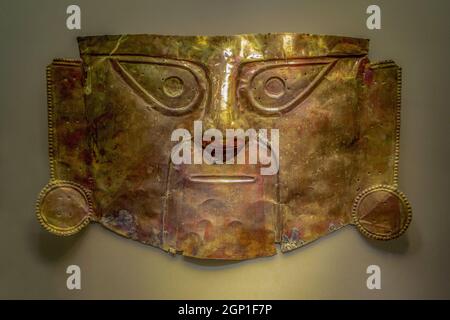 LIMA, PERU - Sep 24, 2021: Golden funeral mask of the Peruvian inca culture. This piece is located in the BCRP museum. Stock Photo