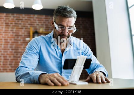 Mature Man Using Magnifying Glasses For Reading Text On Smartphone Stock  Photo - Alamy