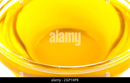 Pouring cooking oil a small glass cup isolated on white background Stock Photo