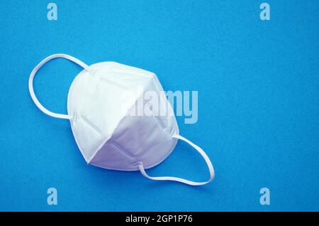 KN95 or N95 FFP2 mask for protection pm 2.5 and corona virus (COVID-19). Anti pollution mask.air face mask, FFP2 N95 mask on blue background. Stock Photo