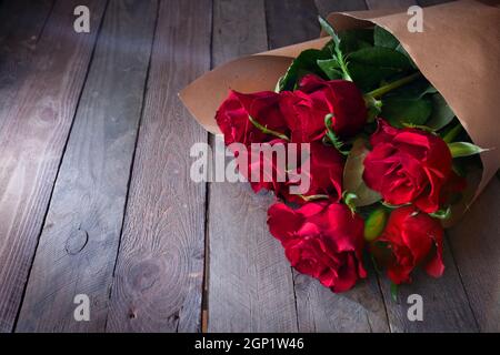 Bunch of red roses on vintage wood. Background for valentines day and mothers day with space for your text. Stock Photo