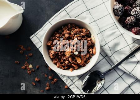 Frozen blackberries, granola, cream, towel on table. Blurred background. High quality photo Stock Photo