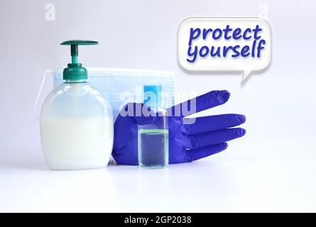 Protective face mask, soap, antiseptic, gloves against virus on white background. Protect your self words on spech bubble Stock Photo