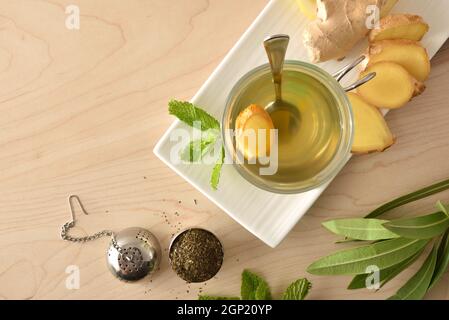 Cup of green tea with ginger lemon and mint on wooden table with leaves on wooden table. Top view. Stock Photo