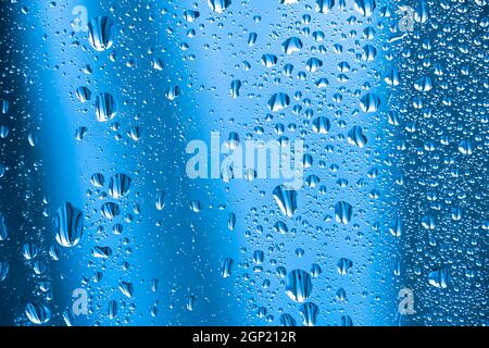 Abstract background ornament with water drops.Raindrops on the glass in rainy weather.The glittering, shiny surface of water on glass.Water drops in t Stock Photo