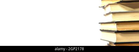Banner, Stack of books on a white background. The books are on top of each other close-up. Side view. Stock Photo