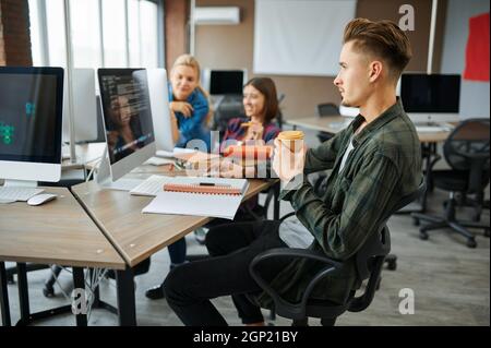 Young IT specialists works on computers in office. Web programmer or designer at workplace, creative occupation. Modern information technology, corpor Stock Photo
