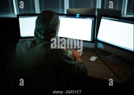 Cyber criminal hacking system at monitors, hacker hands at work ...