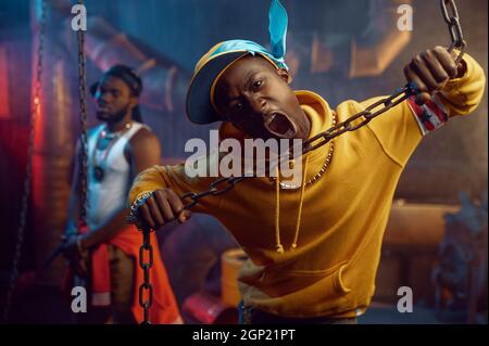Two rappers posing, performing in cool studio, underground decoration ...